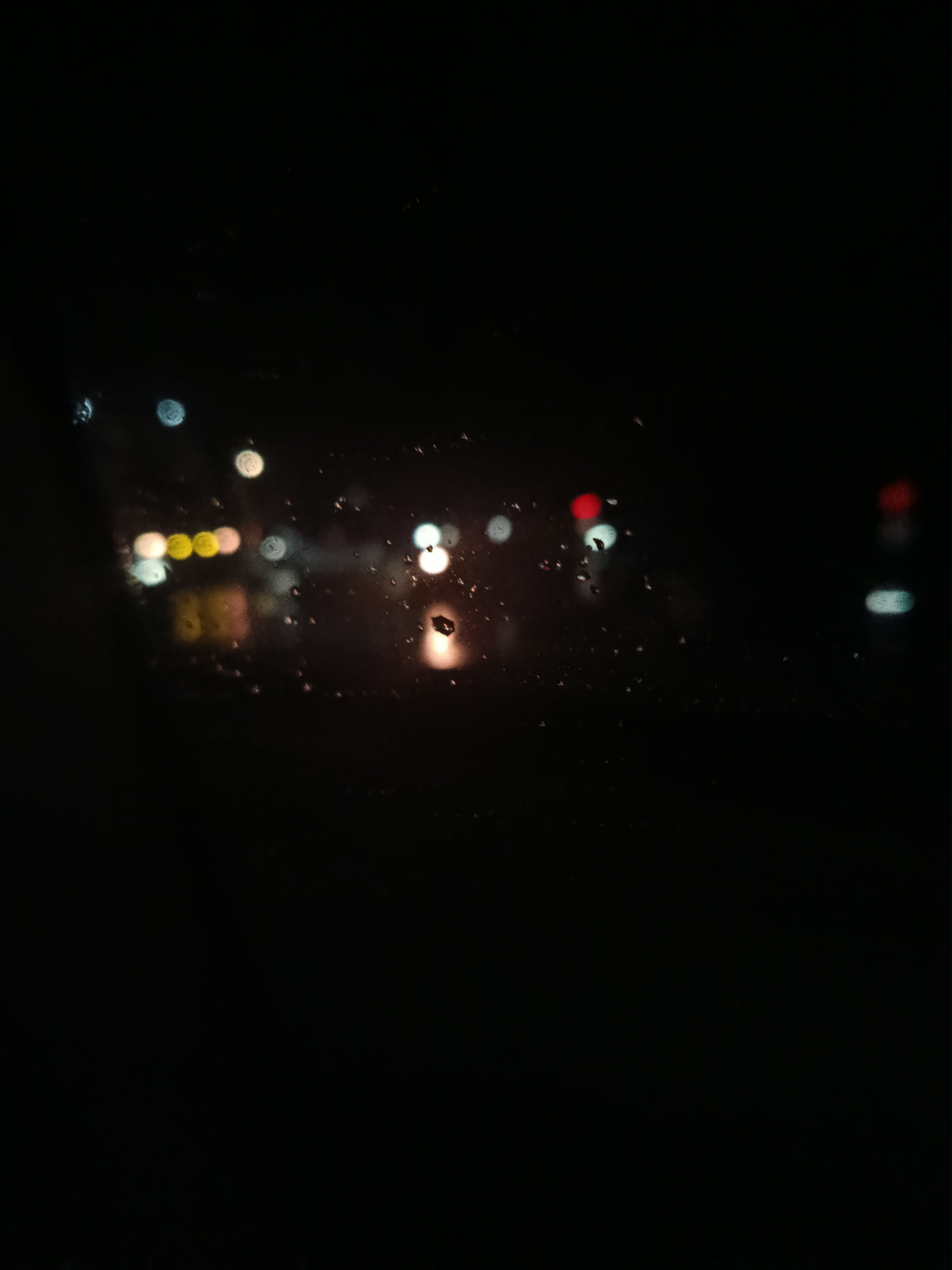 Dew and rain marks on a car window at night